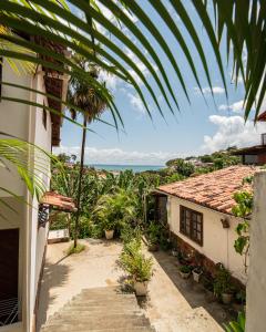 a house with a balcony with a view of the ocean at Apartamentos Quintal - 2 Quartos Suítes e Sala in Morro de São Paulo