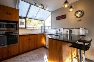 a kitchen with wooden cabinets and a large window at 40c Scarborough Tce in Hanmer Springs