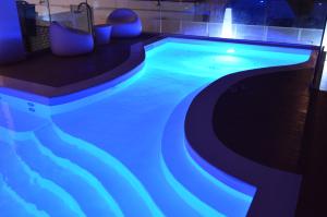 a swimming pool with blue lighting in a building at Hotel Villa Paola in Rimini