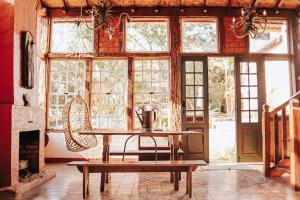 stół i krzesło w pokoju z oknami w obiekcie Pousada d'Oleo de Guignard w mieście Tiradentes