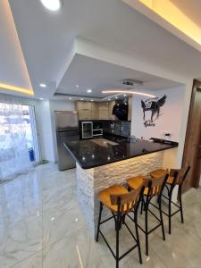 a kitchen with a bar with four chairs around it at Tonny House in La Marsa