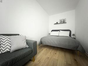 une chambre avec un lit et un canapé dans l'établissement Wohlfühl-Oase mitten in der Stadt - Garten, Grill, Netflix und Drucker, à Leipzig