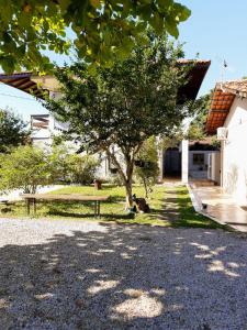 un árbol frente a una casa con un banco en Residencial de Los Pájaros, en Florianópolis