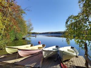 three boats sitting on a dock on a lake at Kaukajärven Joutsen - valoisa ja tilava kaksio in Tampere