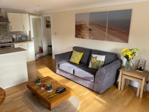 ein Wohnzimmer mit einem Sofa und einem Tisch in der Unterkunft Lovely apartment in beautiful coastal village in Weybourne