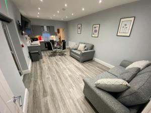 a living room with a couch and a kitchen at Edward Place Luxury Hot Tub Apartments in Blackpool