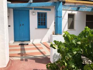 a blue door on the side of a house at Andrebyke terrace in Gergei