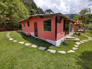 a small house in a yard with rocks around it at Chalés Horizonte Vertical in Aiuruoca