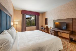 a hotel room with a bed and a flat screen tv at The Lodge at Big Sky in Big Sky