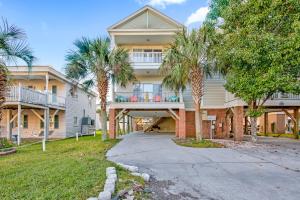 a large house with palm trees in front of it at Alohalani at Surfside Beach in Myrtle Beach