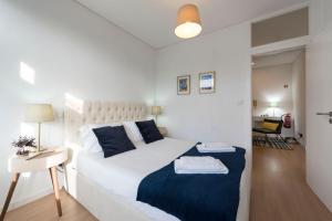 - une chambre avec un lit blanc et une couverture bleue dans l'établissement Purely Porto, à Porto