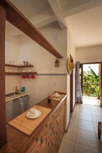 Una cocina con un mostrador con una mesa dentro. en Apartamentos Quintal, en Morro de São Paulo 69 fotos más