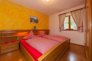 una camera con letto in legno e lenzuola rosse di Gästehaus Arnspitzblick a Scharnitz