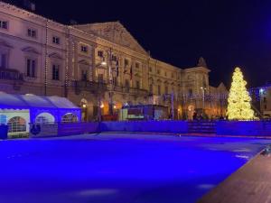 oświetlone choinkę świąteczną przed budynkiem w obiekcie Casa Lumiere w Aoście