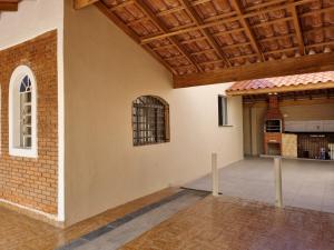 Habitación con pared de ladrillo y techo de madera. en Confortável casa com piscina e churrasqueira a 100m da praia, en Caraguatatuba