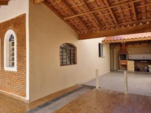 a room with a brick wall and a wooden ceiling at Acolhedora casa renovada - Piscina e a 100m da praia in Caraguatatuba