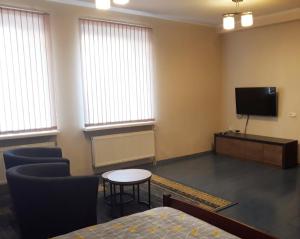 a room with a tv and a table and chairs at Town Center Studio Apartment in Daugavpils