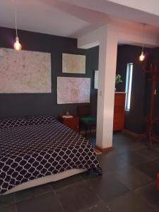1 dormitorio con 1 cama con pared negra en Camino al Cuadrado en Río Ceballos