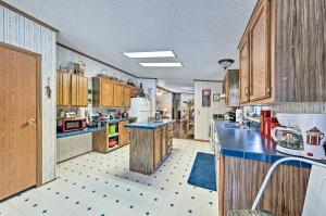 a large kitchen with wooden cabinets and blue counter tops at Haven in the Woods with 150 Acres, 2 Ponds 