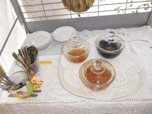 einen weißen Tisch mit einem Tablett mit Honig drauf. in der Unterkunft Arethousa in Plaka Milos
