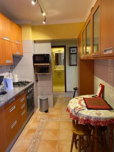 a kitchen with a small table and a kitchen with a yellow door at Castelo I in Quarteira