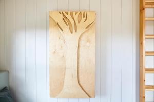 a wooden picture of a tree hanging on a wall at Aileen - Unique tiny house with wood fired roll top bath in heart of the Cairngorms in Ballater