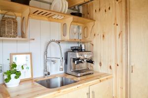 a kitchen with a sink and a microwave at Aileen - Unique tiny house with wood fired roll top bath in heart of the Cairngorms in Ballater