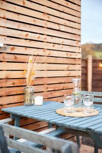 a blue table with glasses on a wooden wall at Aileen - Unique tiny house with wood fired roll top bath in heart of the Cairngorms in Ballater