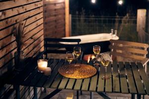 a table with glasses of wine and candles on it at Aileen - Unique tiny house with wood fired roll top bath in heart of the Cairngorms in Ballater