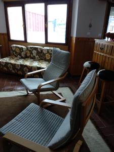 sala de estar con 2 sillas y sofá en Peña del viento a pie de pistas estación San Isidro en Puebla de Lillo