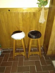 two black and white stools sitting next to a wall at Peña del viento a pie de pistas estación San Isidro in Puebla de Lillo