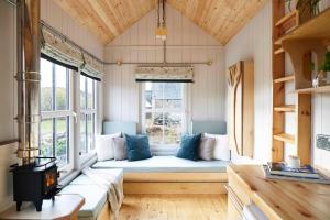 a large room with a couch in a window at Aileen - Unique tiny house with wood fired roll top bath in heart of the Cairngorms in Ballater