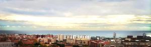 a view of a city with the ocean and buildings at Hostal Isla Cristina Mataro in Mataró
