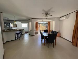 a dining room and kitchen with a table and chairs at Family oriented house just steps to the beach in Jacó