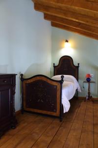 1 dormitorio con 1 cama y suelo de madera en Agriturismo Corte Lidia, en Bellaguarda
