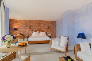 a bedroom with a bed, a chair, and a lamp at Charleston Santa Teresa Cartagena in Cartagena de Indias