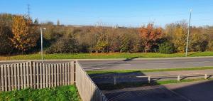 an empty road with a fence on the side of the road at Garland Modern 4 Bedroom House with Garden & Parking in Kent