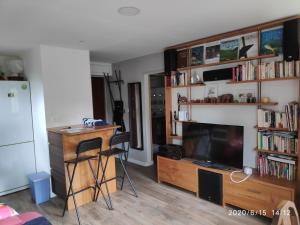 uma sala de estar com uma televisão, uma mesa e uma secretária em Appt Seignosse le Penon - plages commerces à pied em Seignosse