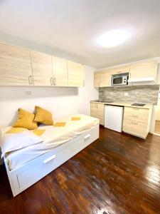 a bedroom with a white bed and a kitchen at Luna's Cozy Apartment, skiin skiout in centre CIR 17 in Breuil-Cervinia