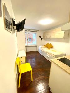 a small kitchen with a yellow chair in a room at Luna's Cozy Apartment, skiin skiout in centre CIR 17 in Breuil-Cervinia