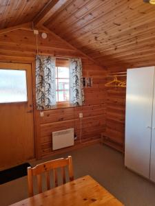 a dining room with a table and a refrigerator at Sonfjällscampen in Hede