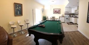 a living room with a pool table and a kitchen at Single family home in Fort Washington