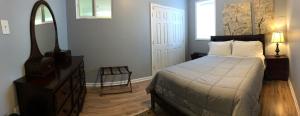 a bedroom with a bed and a dresser and a mirror at Two bedroom apartment in single family home in Fort Washington