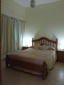 1 dormitorio con 1 cama con cabecero de madera en Casa Huerta en Vista Flores