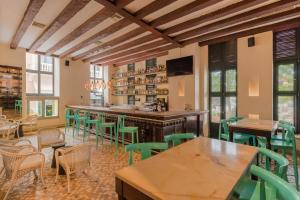 a restaurant with green chairs and a bar at Charleston Santa Teresa Cartagena in Cartagena de Indias