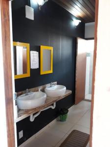 a bathroom with two sinks and two mirrors at Ti Hostel Trindade Hospeda in Trindade