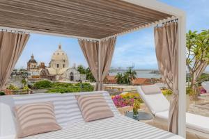 Schlafzimmer mit einem Bett und Stadtblick in der Unterkunft Charleston Santa Teresa Cartagena in Cartagena de Indias