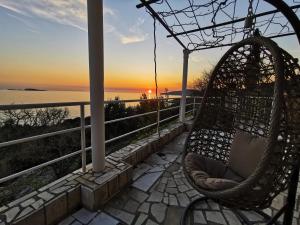 una hamaca en un porche con la puesta de sol en el fondo en Holiday Apartment Lira jacuzzi - sea view- terrace en Mlini