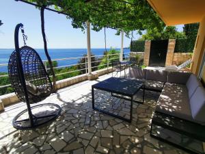 a patio with a couch and a swing and the ocean at Holiday Apartment Lira jacuzzi - sea view- terrace in Mlini