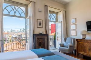 a bedroom with a bed and a large window at Casa do Cativo in Porto